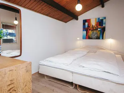 a bedroom with a bed in a room with a mirror at 4 person holiday home in Thisted-By Traum in Thisted