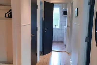 a hallway with two open doors and a bathroom at Centralt beliggende hyggeligt byhus med 8 sovepladser 130m2 med pejs in Holstebro