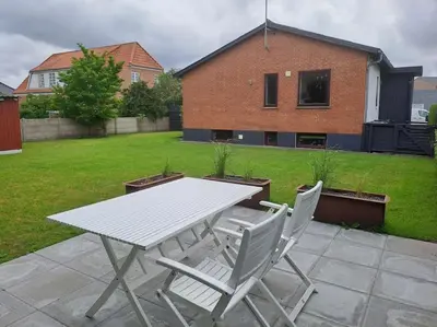 a white table and chairs on a patio at Centralt beliggende hyggeligt byhus med 8 sovepladser 130m2 med pejs in Holstebro