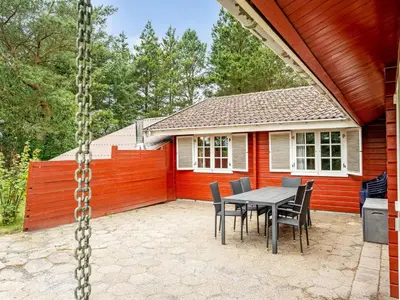 a patio with a table and chairs in front of a house at Holiday Home Aisling - 700m from the sea by Interhome in Brovst
