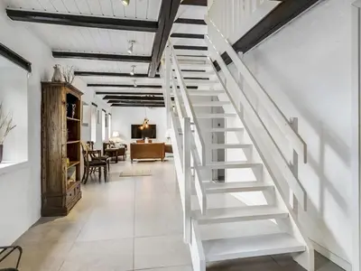 a white staircase in a hallway with a living room at Apartment Thorgot - 3km from the sea by Interhome in Pandrup