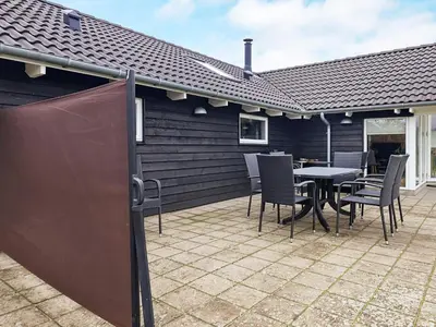 a patio with a table and chairs on it at 14 person holiday home in Højslev in Sundstrup