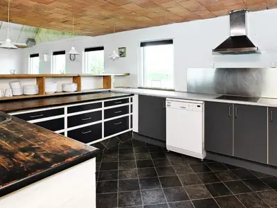 a large kitchen with black and white appliances at 14 person holiday home in Løgstør-By Traum in Løgstør