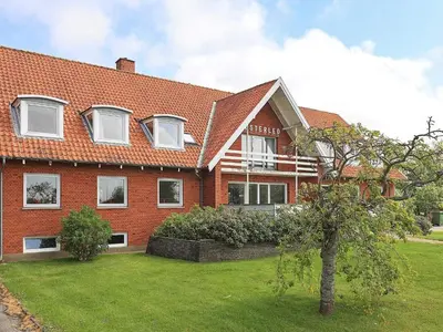 a large red brick house with a green yard at Rustic Retreat in Gettrup - By Traum Ferienwohnungen in Sindrup