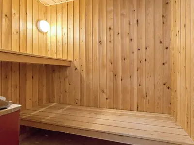 a sauna with wood paneling and a light on the wall at 8 person holiday home in Hurup Thy-By Traum in Sindrup