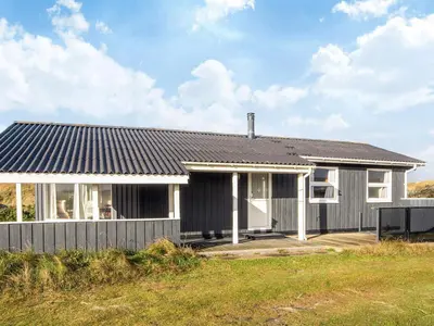 a house with a black roof and a yard at Seaside Escape with Swing in Vrist