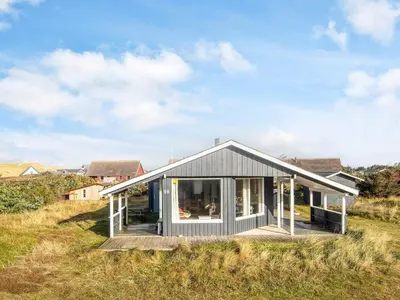 a house on a hill with a wooden deck at Seaside Escape with Swing in Vrist