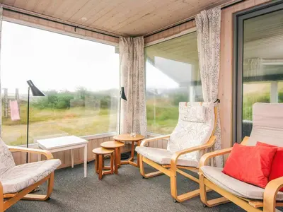 a screened in porch with chairs and a table at Seaside Escape with Swing in Vrist