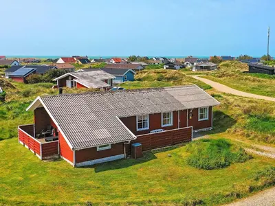 a small house on top of a grassy hill at Family-friendly Retreat near Beach - By Traum Ferienwohnungen in Lild Strand