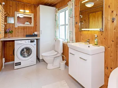 a bathroom with a toilet sink and a washing machine at Family-friendly Retreat near Beach - By Traum Ferienwohnungen in Lild Strand