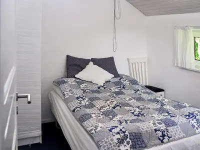 a bedroom with a bed with a blue and white quilt at 6 person holiday home in Struer-By Traum in Remmer Strand