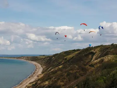 a bunch of kites flying in the sky over the ocean at 6 person holiday home in Struer-By Traum in Remmer Strand