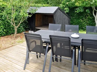a black dining table and chairs with a dog house at 6 person holiday home in Struer-By Traum in Remmer Strand
