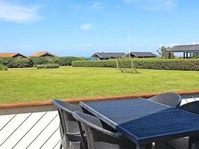 a table and chairs on a deck with a playground at 10 person holiday home in Vinderup-By Traum in Vinderup