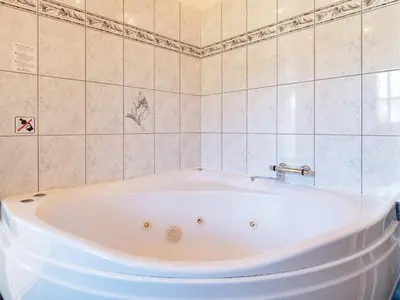 a white bath tub in a tiled bathroom at 8 person holiday home in Løgstrup-By Traum in Hjarbæk