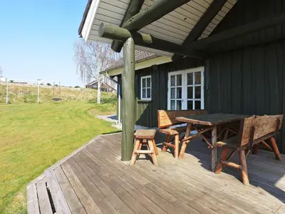 a wooden deck with a table and chairs on a house at 8 person holiday home in Løgstrup-By Traum in Hjarbæk