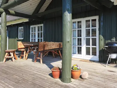 a wooden deck with a picnic table and a grill at 8 person holiday home in Løgstrup-By Traum in Hjarbæk