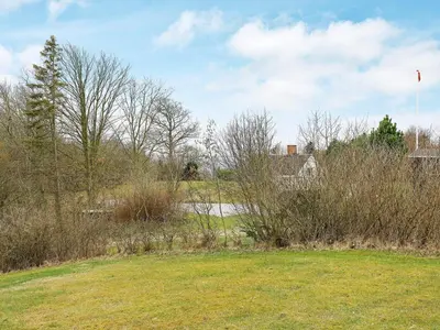 a field of grass with a house and a river at 8 person holiday home in Spøttrup-By Traum in Lihme