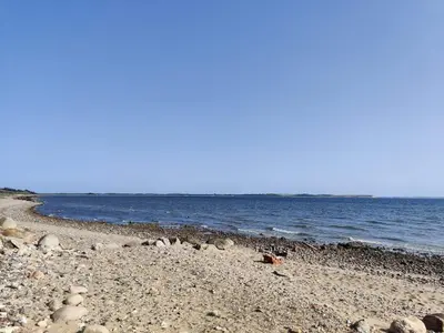 a beach with rocks and the ocean on a sunny day at 8 person holiday home in Spøttrup-By Traum in Lihme