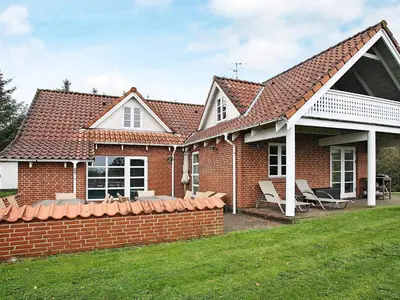 a red brick house with a brick retaining wall at 10 person holiday home in Fur-By Traum in Fur