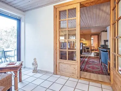 a living room with a wooden door and a table at 12 person holiday home in Pandrup-By Traum in Rødhus