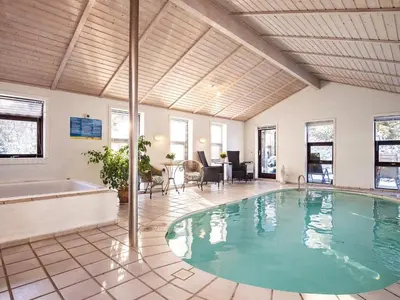 a large swimming pool in a room with a tub at 12 person holiday home in Pandrup-By Traum in Rødhus