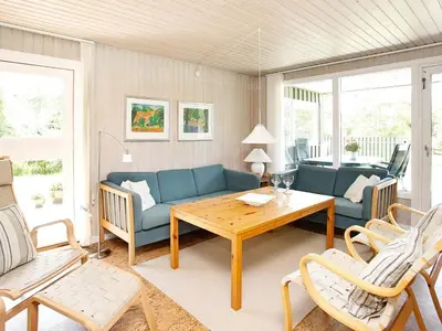 a living room with a blue couch and a table at 6 person holiday home in Pandrup-By Traum in Rødhus