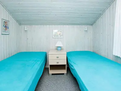 two beds in a small room with blue sheets at Luxury Pool Villa Retreat - By Traum Ferienwohnungen in Blokhus
