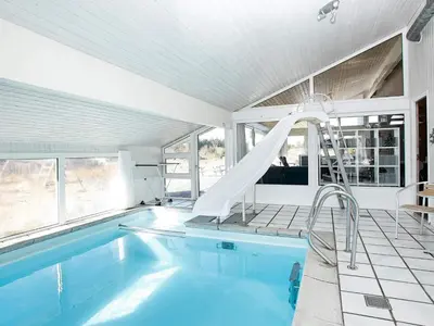 a swimming pool with a slide in a house at Luxury Pool Villa Retreat - By Traum Ferienwohnungen in Blokhus