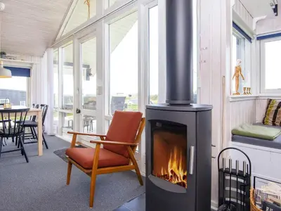 a fireplace in a room with a chair and a table at 4 person holiday home in Lemvig-By Traum in Lemvig