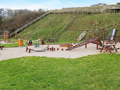 a park with a playground with wooden play equipment at 4 person holiday home in Lemvig-By Traum in Lemvig