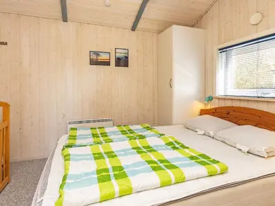 a bedroom with a large bed with a striped comforter at Fjordview Retreat with Spa - By Traum Ferienwohnungen in Sillerslev