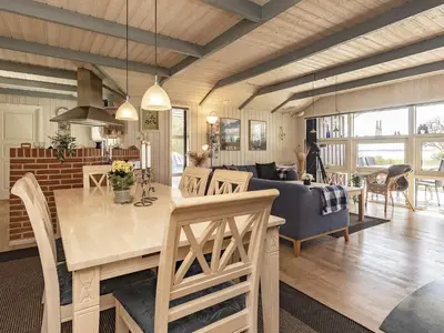 a kitchen and living room with a table and a couch at Fjordview Retreat with Spa - By Traum Ferienwohnungen in Sillerslev