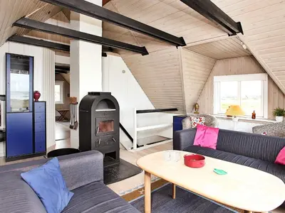 a living room with a couch and a wood stove at Panoramic Sea View Retreat - By Traum Ferienwohnungen in Blokhus