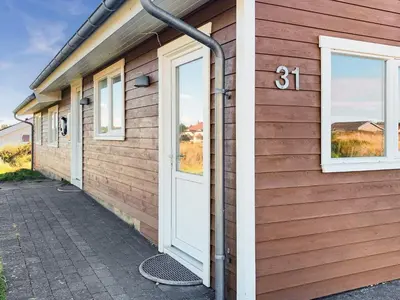 a house with a door on the side of it at 10 person holiday home in Thisted-By Traum in Klitmøller