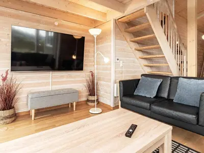 a living room with a black couch and a tv at 10 person holiday home in Thisted-By Traum in Klitmøller