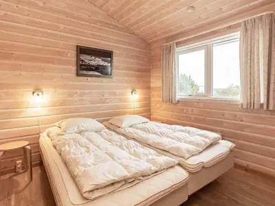 a large bed in a room with wooden walls at 10 person holiday home in Thisted-By Traum in Klitmøller