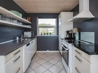 a kitchen with black and white appliances and a window at 8 person holiday home in Vestervig-By Traum in Vestervig