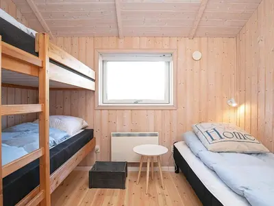a room with two bunk beds and a table at Tranquil Retreat in Klitmoller - By Traum Ferienwohnungen in Klitmøller