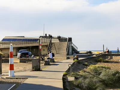 a group of people sitting on a sidewalk near the beach at Tranquil Retreat in Klitmoller - By Traum Ferienwohnungen in Klitmøller
