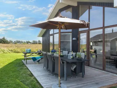 a patio with a table and an umbrella at 7 person holiday home in Ulfborg-By Traum in Thorsminde