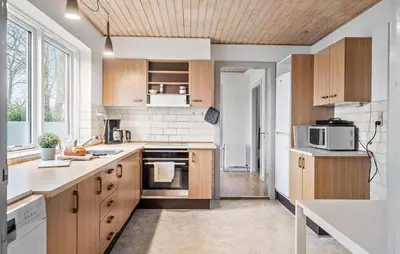 a kitchen with wooden cabinets and a counter top at Lovely Home In Vemb With House Sea View in Vemb