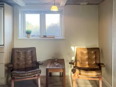 two leather chairs and a table in a room at 4 person holiday home in Lemvig-By Traum in Trans