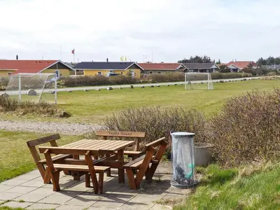 a picnic table with two benches and a soccer field at 6 person holiday home in Harboøre-By Traum in Harboør