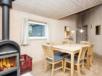 a dining room with a table and a fireplace at 6 person holiday home in Harboøre-By Traum in Harboør