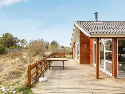 a wooden deck with a bench on a house at Luxury Eco Cottage in Klitmoller - By Traum Ferienwohnungen in Klitmøller