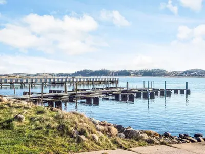 a dock on a body of water with rocks in the water at 8 person holiday home in Højslev-By Traum in Bøstrup