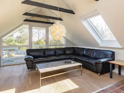 a living room with a black leather couch at 8 person holiday home in Højslev-By Traum in Bøstrup