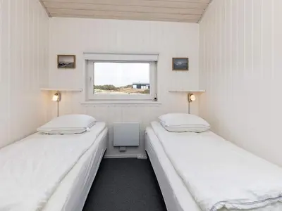 two beds in a small room with a window at Luxury Beachfront Retreat - By Traum Ferienwohnungen in Rødhus