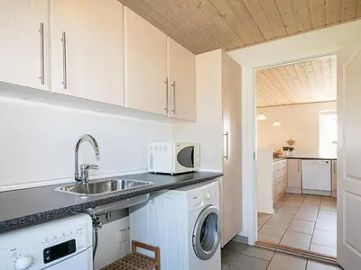 a kitchen with a sink and a washing machine at 8 person holiday home in Skals-By Traum in Sundstrup